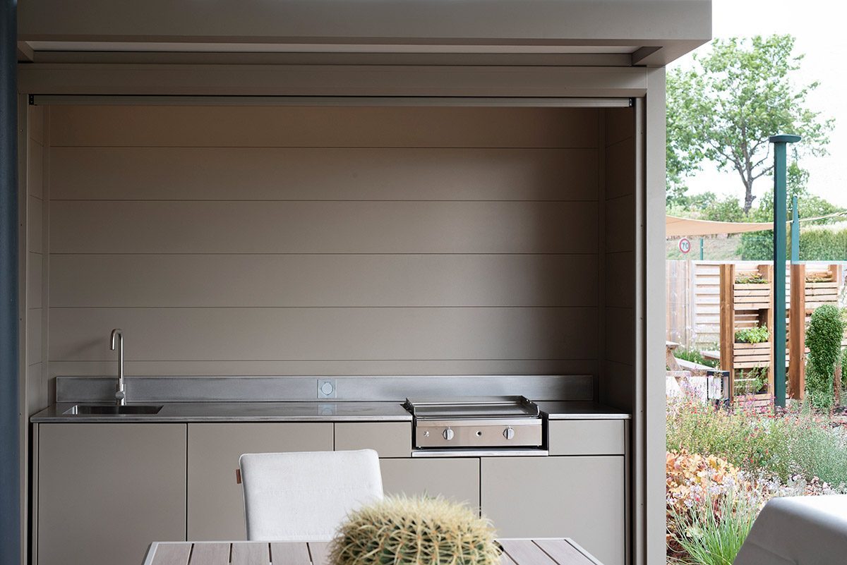 Box ASPIC avec cuisine extérieure sur mesure jardin fleuri, cuisine d'été ASPIC haut de gamme.